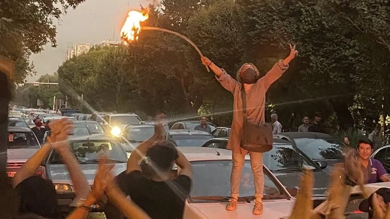A woman set fire to her headscarf during a protest in Tehran on Monday